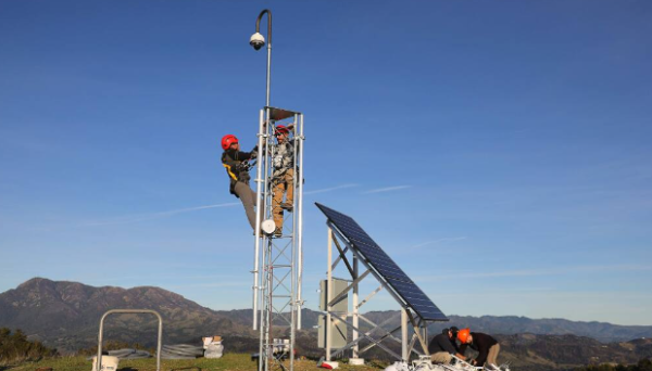 Installation of AI cameras being placed on a tower. 